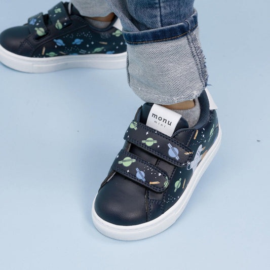 Tenis Astro Azul para niños de Monu Mini, estampado de espacio con cohete y astronauta. Foto con modelo infantil..