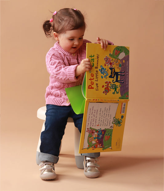 Bebé usando zapatos respetuosos dorados pre-caminadores durante sus primeros pasos, mostrando el ajuste cómodo y la flexibilidad del diseño.