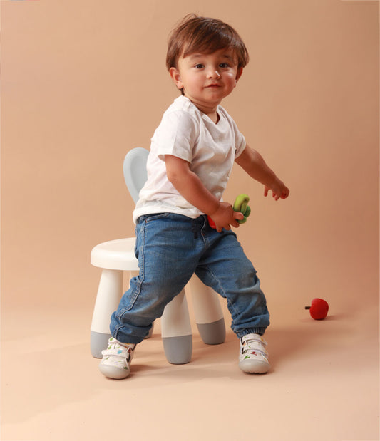 Bebé usando los zapatos respetuosos Pájaros Blanco mientras da sus primeros pasos, con un ajuste perfecto y flexibilidad para moverse con facilidad.