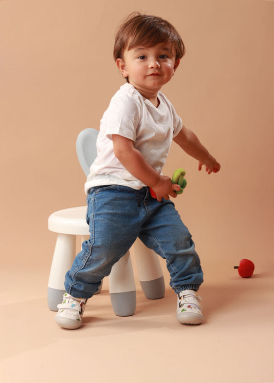 Bebé usando los zapatos respetuosos Pájaros Blanco mientras da sus primeros pasos, con un ajuste perfecto y flexibilidad para moverse con facilidad.