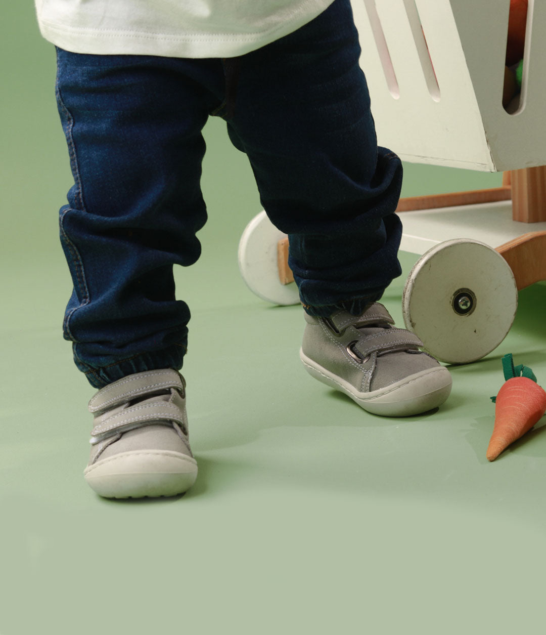 Bebé usando los zapatos respetuosos Gris Estrella mientras da sus primeros pasos, mostrando el ajuste perfecto y la flexibilidad para moverse con facilidad.
