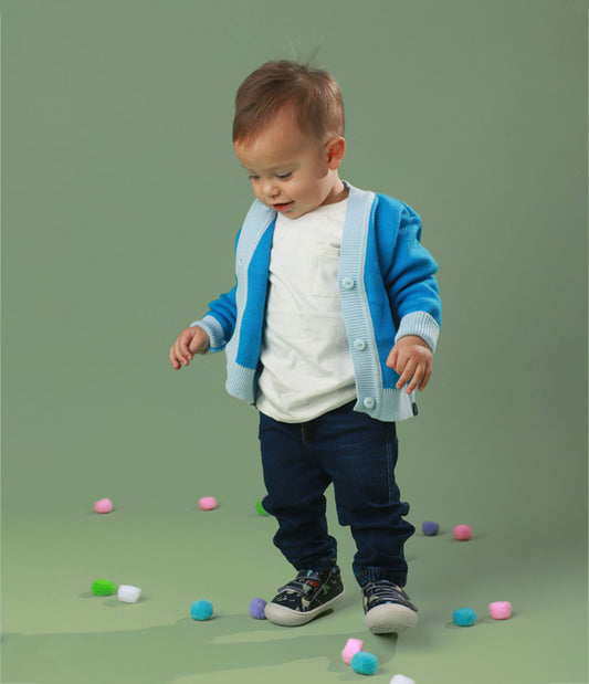 Bebé usando los zapatos respetuosos Pájaros Azul mientras da sus primeros pasos, con un ajuste perfecto y flexibilidad para moverse con facilidad.