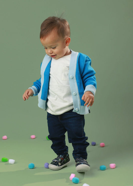 Bebé usando los zapatos respetuosos Pájaros Azul mientras da sus primeros pasos, con un ajuste perfecto y flexibilidad para moverse con facilidad.