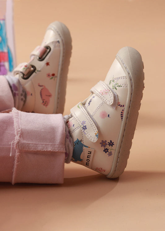 Bebé usando los zapatos respetuosos pre-caminadores Gatos Miau mientras da sus primeros pasos, con un ajuste cómodo y diseño flexible.