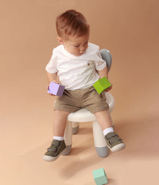 Bebé usando zapatos plateados mientras da sus primeros pasos, con ajuste seguro y flexibilidad para un movimiento natural.