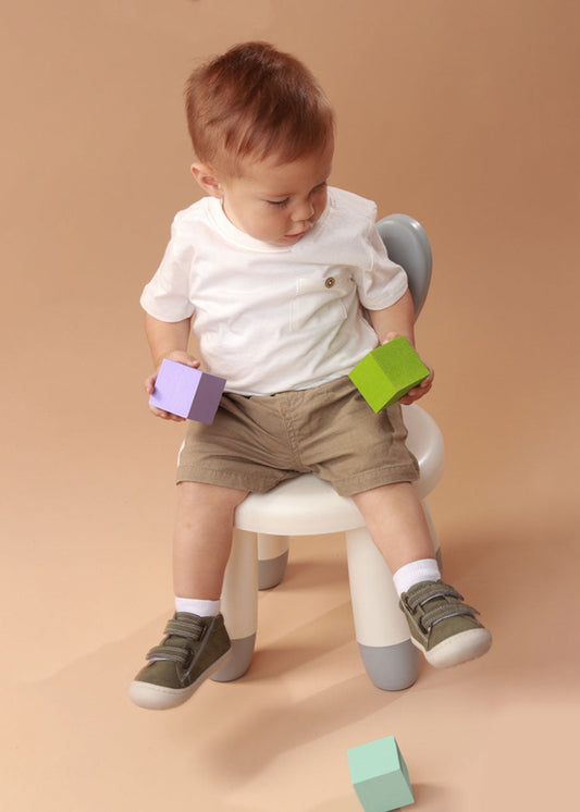 Bebé usando zapatos plateados mientras da sus primeros pasos, con ajuste seguro y flexibilidad para un movimiento natural.