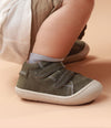 Bebé usando zapatos plateados mientras da sus primeros pasos, con ajuste seguro y flexibilidad para un movimiento natural.